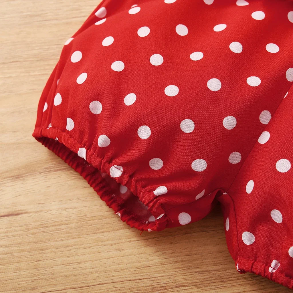 Baby girl enjoying summer in a red polka dot sleeveless bodysuit and shorts set