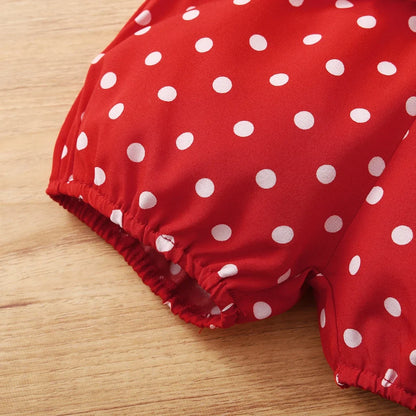 Baby girl enjoying summer in a red polka dot sleeveless bodysuit and shorts set