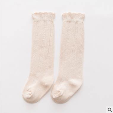 Baby girl in blue ribbed knee-high socks, essential soft cotton baby accessory.