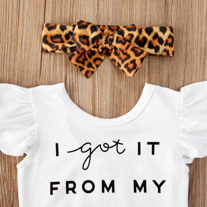 Close-up of infant girl romper featuring 'I Got It From My Mama' script and brown leopard print ruffle skirt