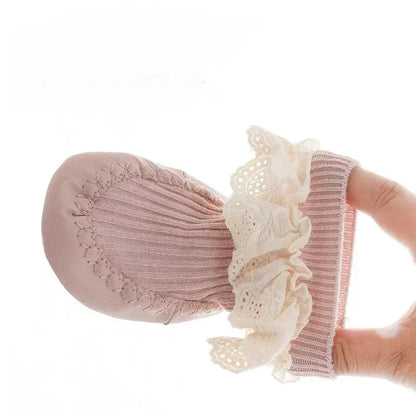 Close-up of anti-slip sole on baby girl's ruffle bow sock shoes for first walkers.