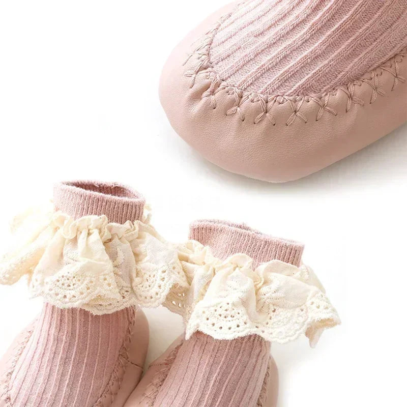 Baby girl wearing pink ruffle bow sock shoes, soft cotton for first steps.
