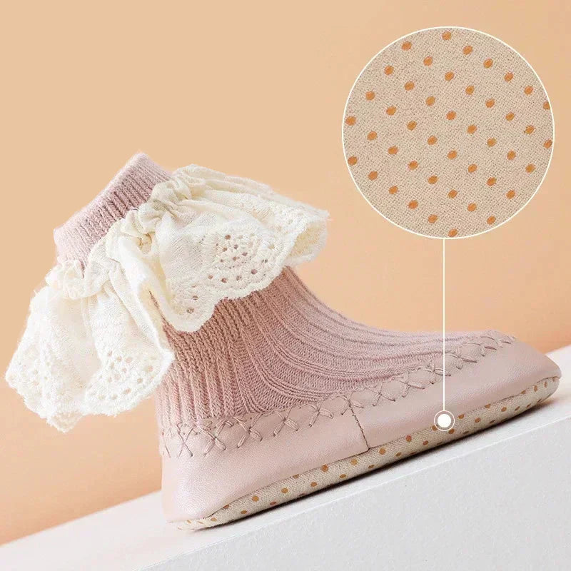 Top view of anti-slip baby girl sock shoes with delicate ruffle and bow detail.