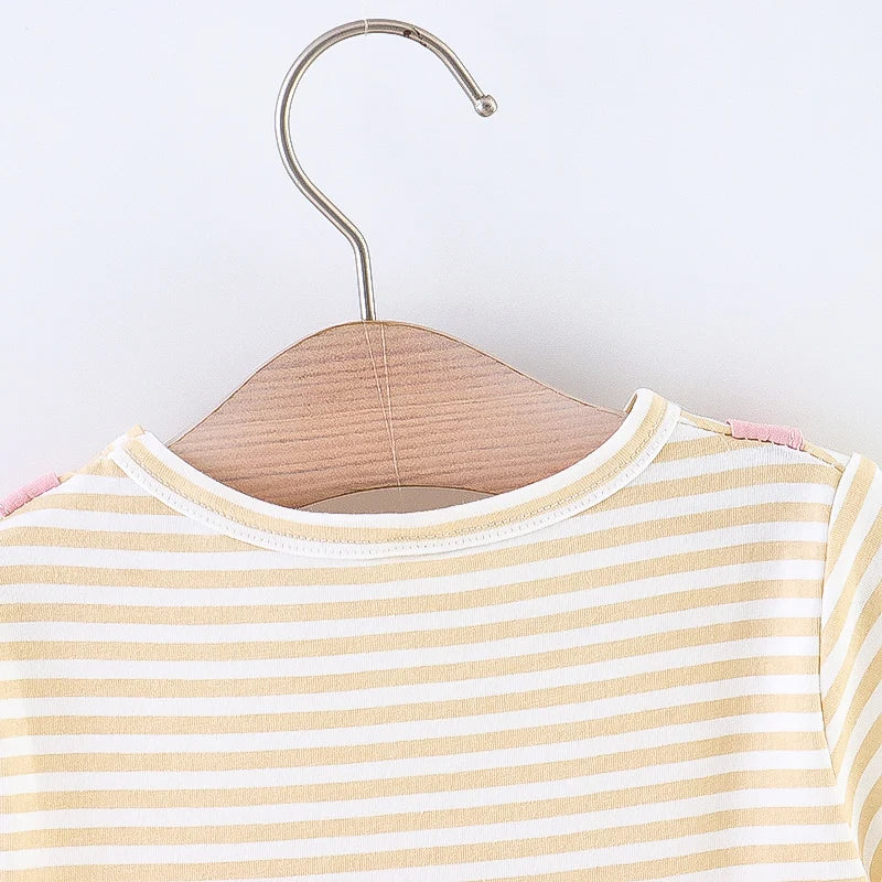 Toddler girl wearing a striped princess dress with a fun cartoon cat design. Kids fashion.