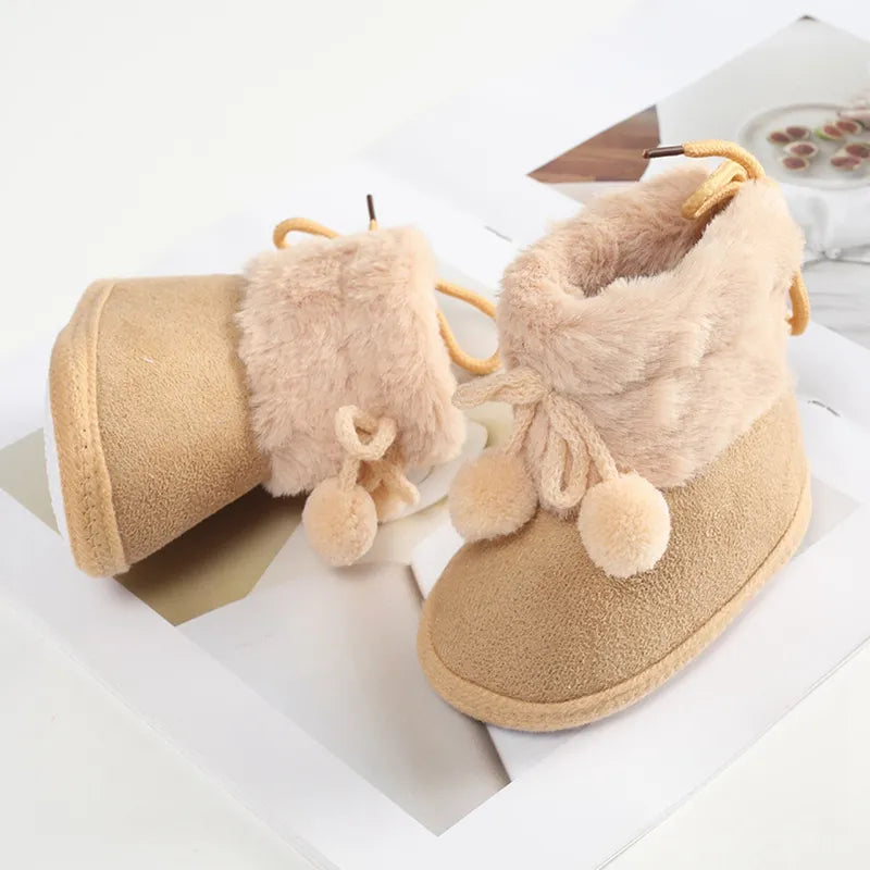 Baby girl's cozy pink winter snow booties with fluff ball detailing, soft sole for newborns