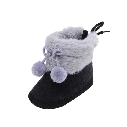 Pair of soft pink baby girl winter boots, fluff ball accent and comfortable soft sole