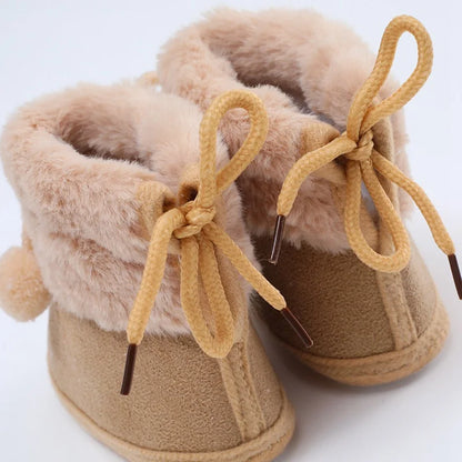 Close-up of the textured soft sole on pink baby girl's winter fluff ball bootie