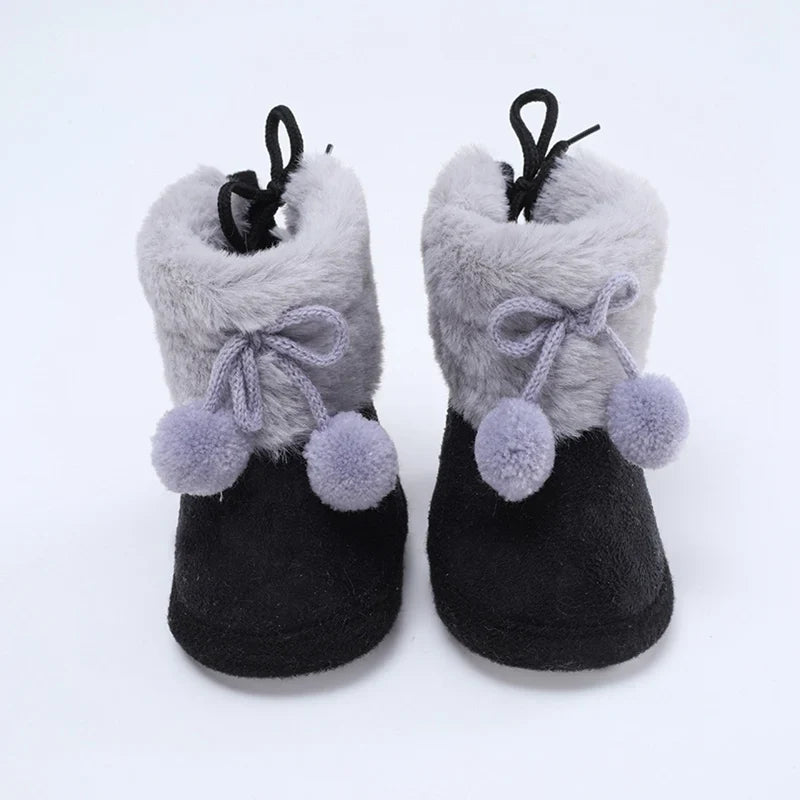 Close-up of pink fluff ball baby winter bootie, ideal soft sole first walker for infant girl
