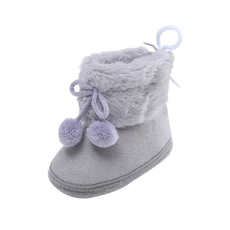 Baby girl's pink winter booties, soft sole ideal for newborns, with a lovely fluff ball feature