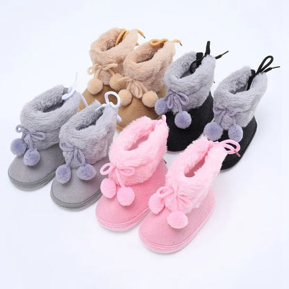 Soft pink baby girl winter booties with charming fluff ball, comfortable first walker shoes