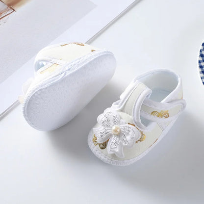 Pink floral baby girl's crib shoes with a soft sole for infants, adorned with a pretty bow, baby fashion.