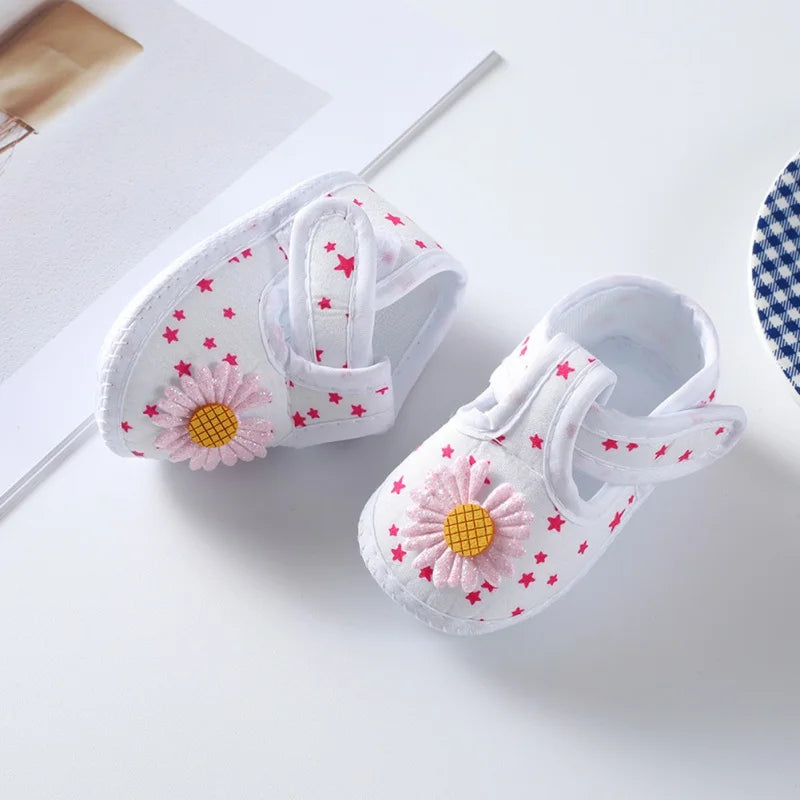 Comfortable baby girl's crib shoes, 100% soft sole with a delightful floral pattern and pink bow detail.