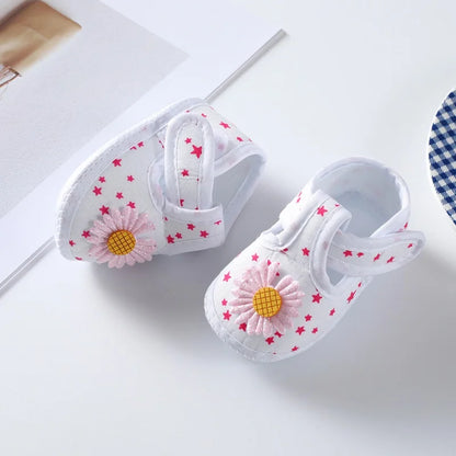 Comfortable baby girl's crib shoes, 100% soft sole with a delightful floral pattern and pink bow detail.