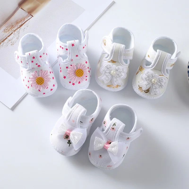 Close-up of baby girl's floral crib shoe, showcasing soft sole and charming pink bow, perfect for infants.