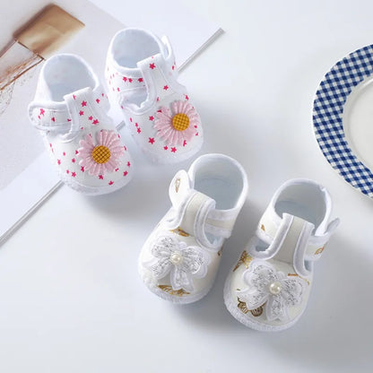 Pair of baby girl's soft sole crib shoes, featuring a beautiful floral design and decorative bow, autumn style.