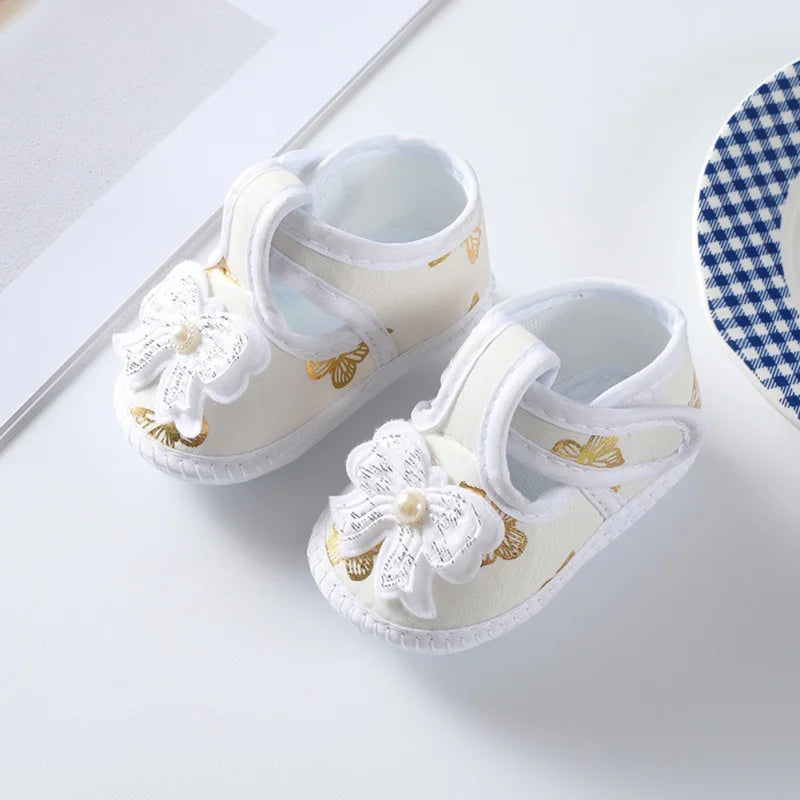 Delicate floral pattern on baby girl's crib shoes with a soft sole and charming bow accent, ideal for babies.