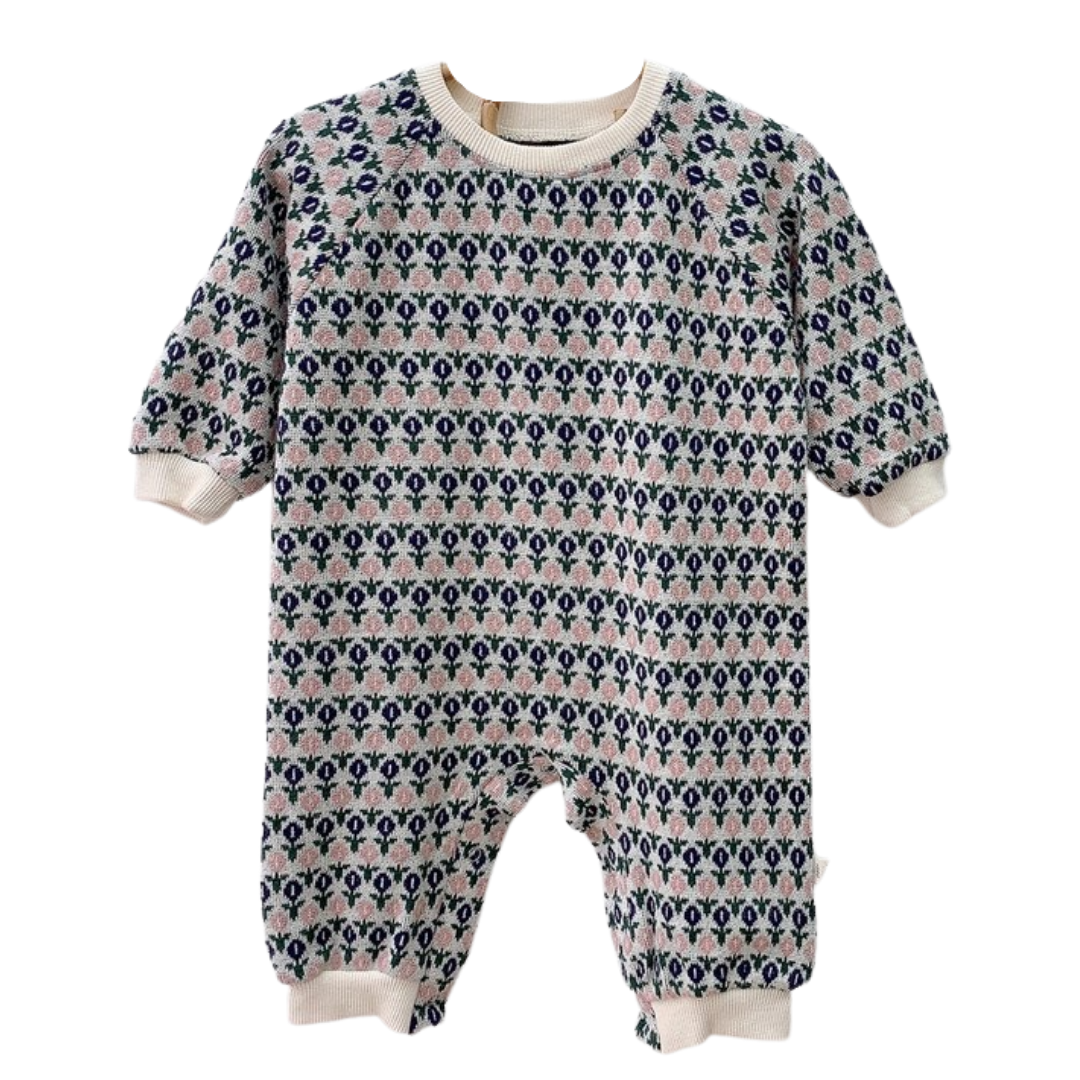 Close-up of a cozy, long sleeve knitted floral romper for baby girls, ideal baby outfit.