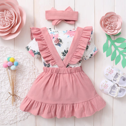 Cute infant fashion: baby girl in a pink floral skirt and matching bow headband