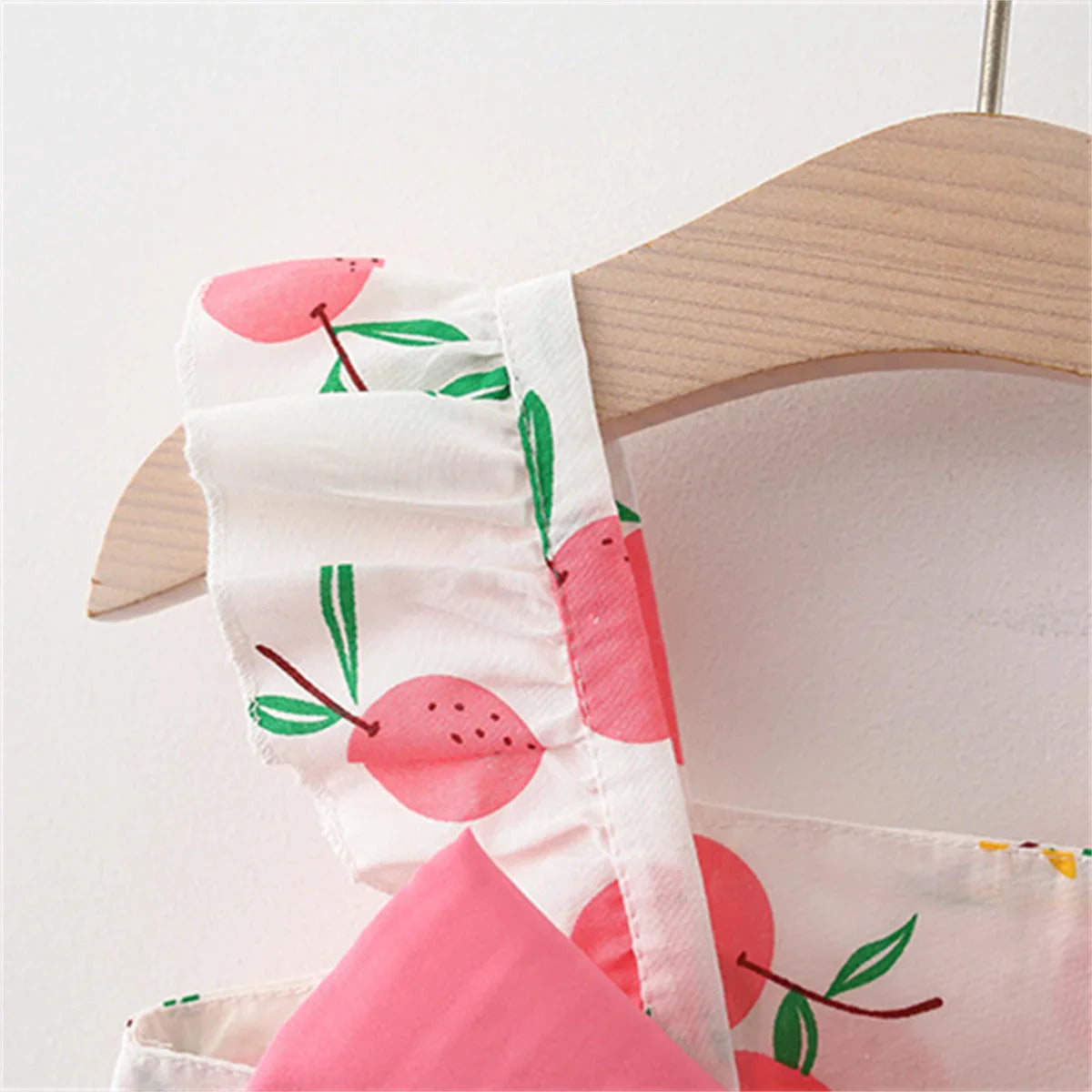 Soft cotton baby dress with a vibrant fruit print and a matching broad-brim hat.