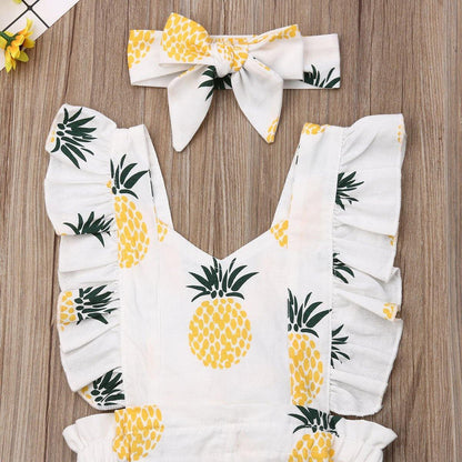 Adorable baby girl in a yellow pineapple print summer romper and matching headband, a cute infant outfit