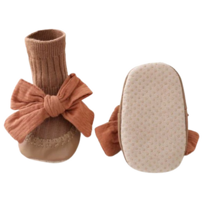 Detailed shot of the anti-slip sole on baby girl's cotton sock walker shoes, secure for first steps