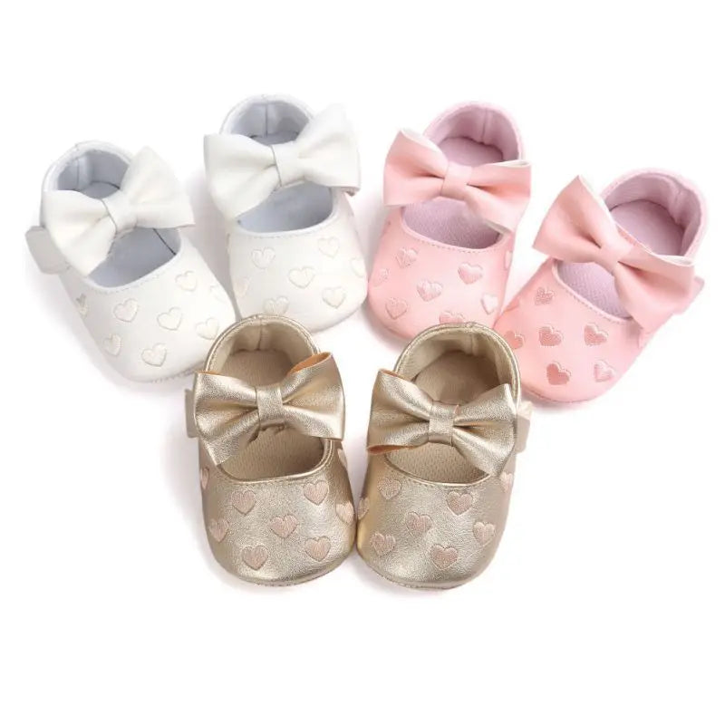 Close-up of the soft sole and breathable fabric on baby girl first walker shoes, pink with bow