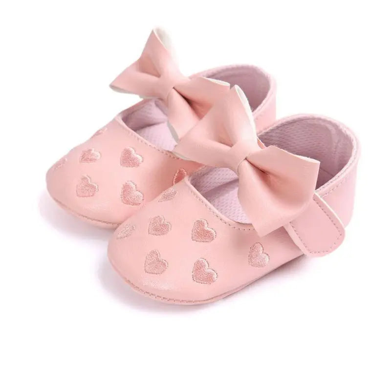 Top view of non-slip infant footwear in pink for baby girls, featuring a cute decorative bow