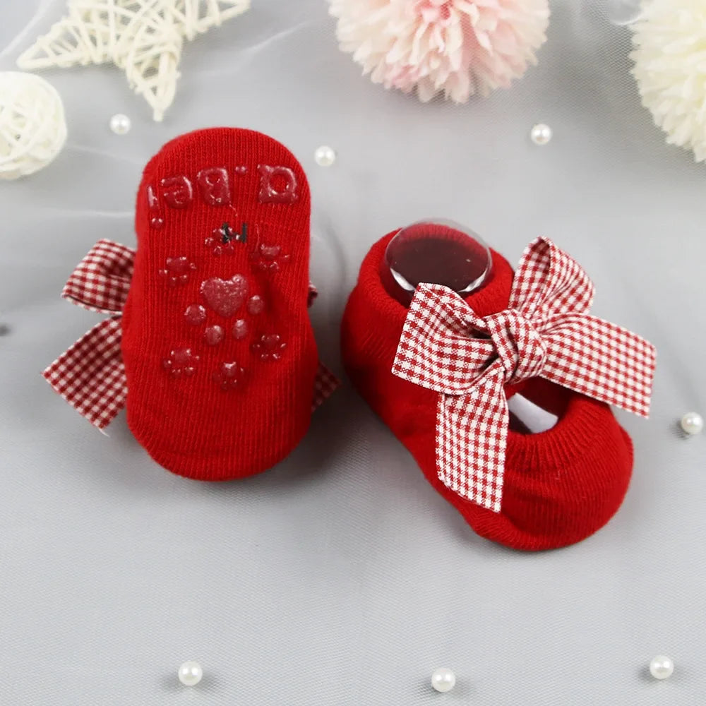 Infant anti-slip socks in a pastel yellow with cute bow for baby girls