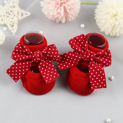 Pink cotton baby girl socks with a charming bow and anti-slip grips