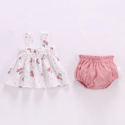 Close-up of square collar on baby girl's summer mini dress, featuring soft pink cotton blend fabric