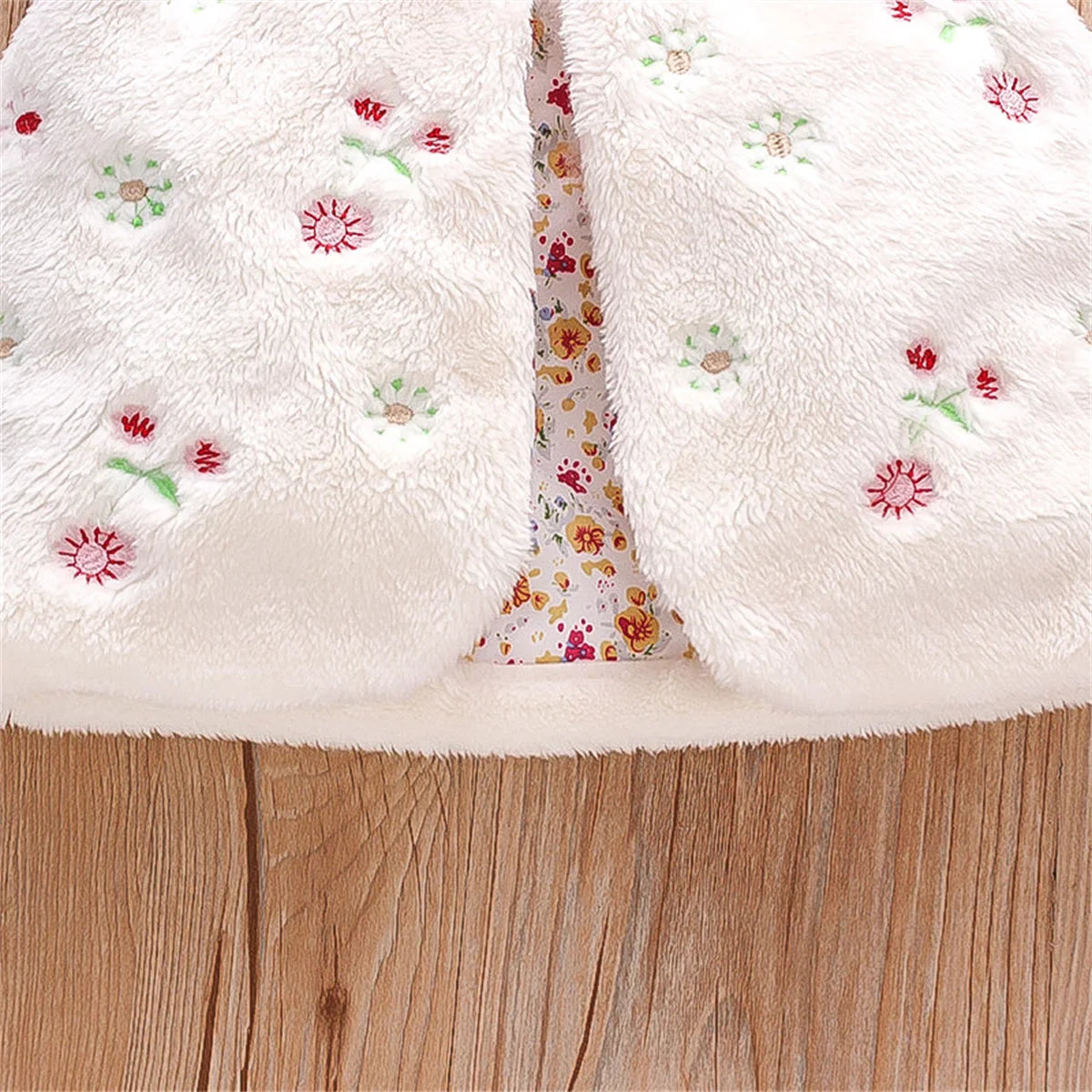 Sleeveless pink faux fur vest for baby girls, highlighting beautiful embroidered flowers.