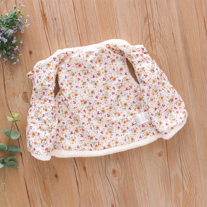 Zoomed-in shot of the flower embroidery against the soft texture of the pink baby vest.