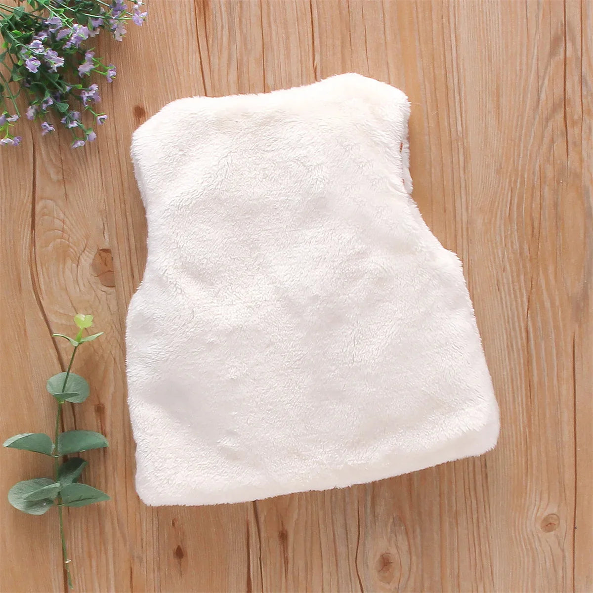 Close-up of flower embroidery on a soft pink baby girl's faux fur vest, winter fashion.