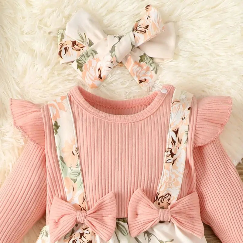 Close-up of pink floral baby romper, showing delicate spring autumn floral pattern on cotton blend