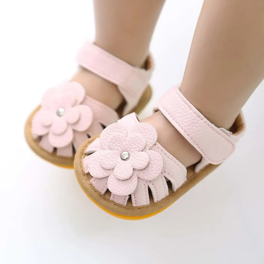 Close-up of white PU leather baby sandals with 3D flower detail and flat heel