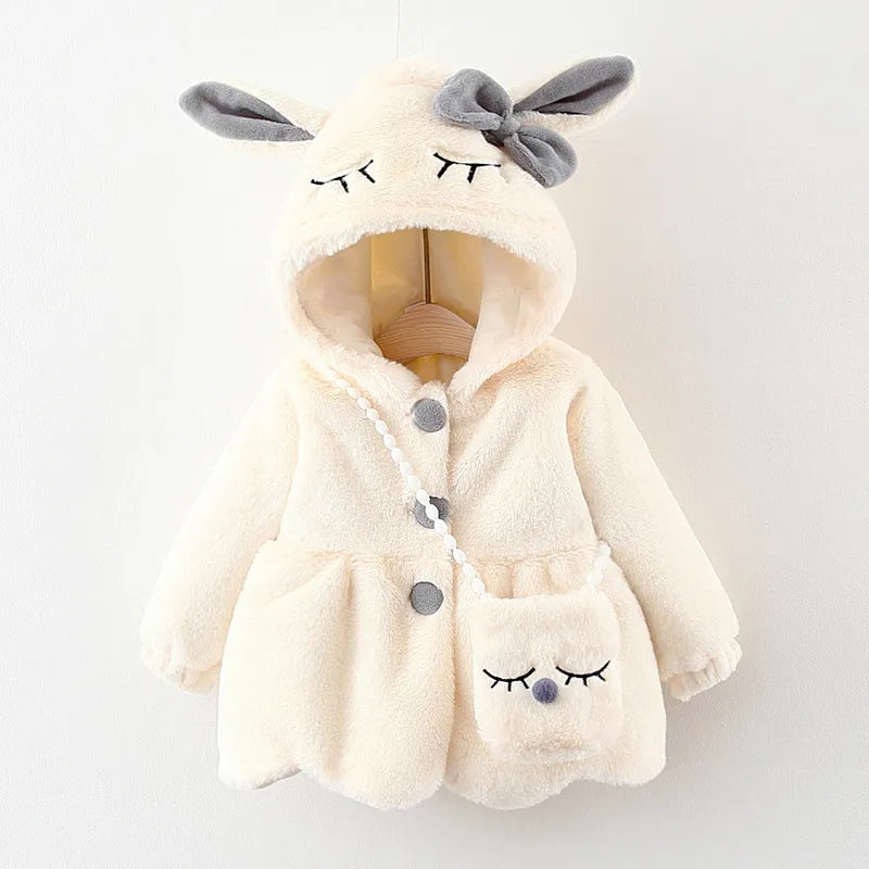 Baby girl in a stylish pink winter jacket with adorable rabbit ears and cozy hood.