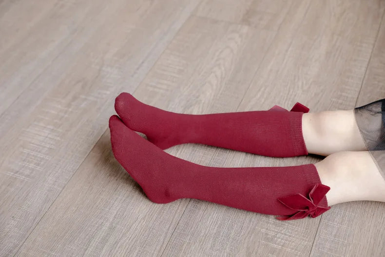 Girls' accessories: Close-up of comfortable knee-high socks with a satin bow for toddlers.