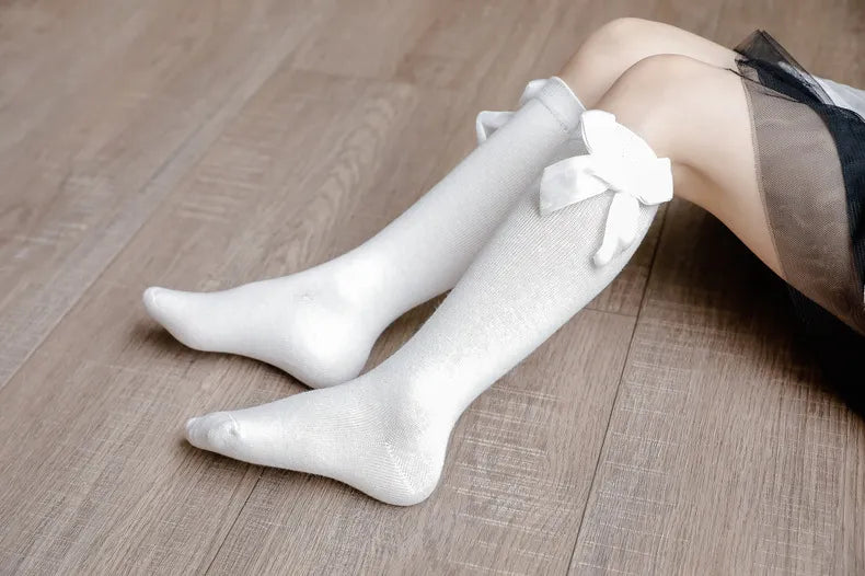 Baby fashion essential: Pale green knee-high socks for girls, embellished with a cute bow.