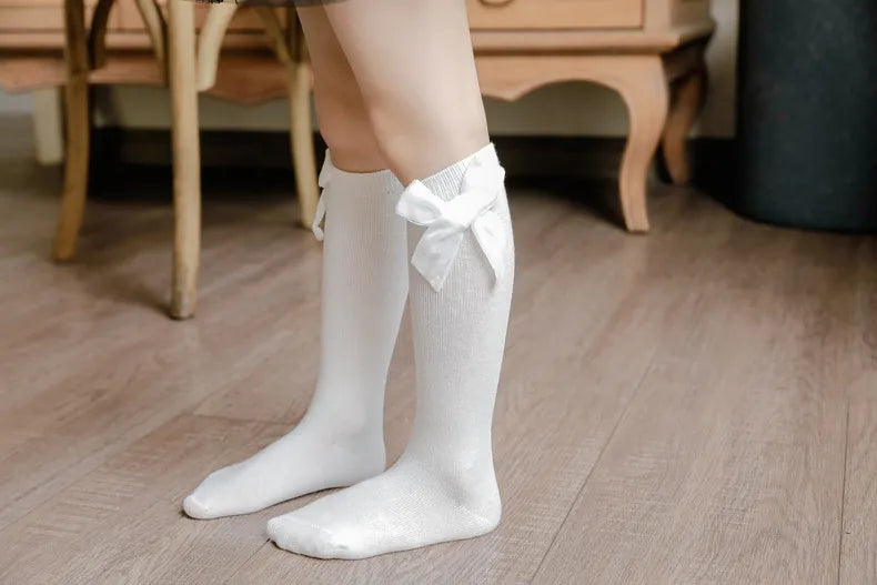 Colorful array of knee-high bow socks for baby girls, showcasing different vibrant shades.