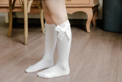 Colorful array of knee-high bow socks for baby girls, showcasing different vibrant shades.