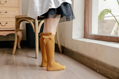 Comfortable cotton blend knee-high socks for baby girls, featuring a charming bow accent.