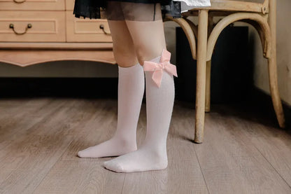 Pack of assorted color knee-high bow socks, ideal for various baby girl fashion styles and outfits.