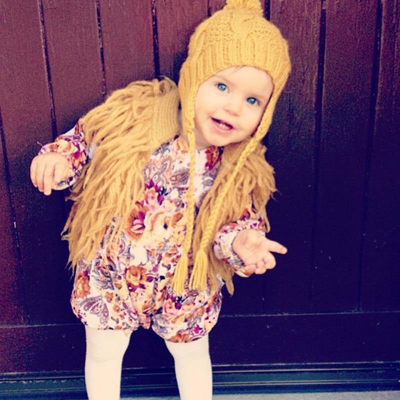 Close-up of a baby girl's knitted vest with delicate tassels, wool cardigan texture.