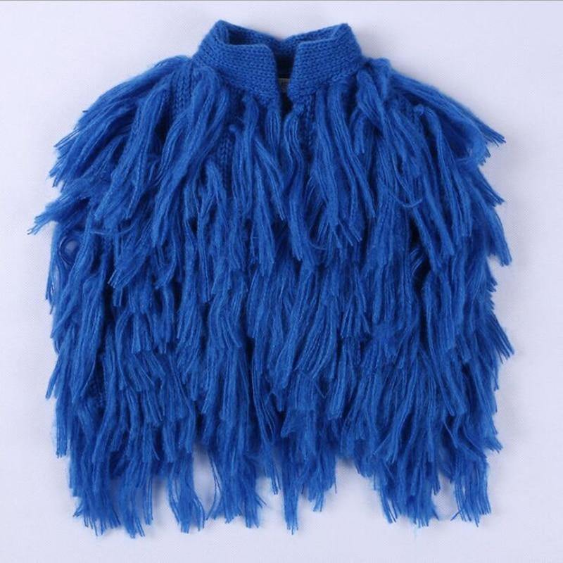 Knitted baby shrug in a vibrant color, featuring cute tassels and sleeveless design, children's fashion.