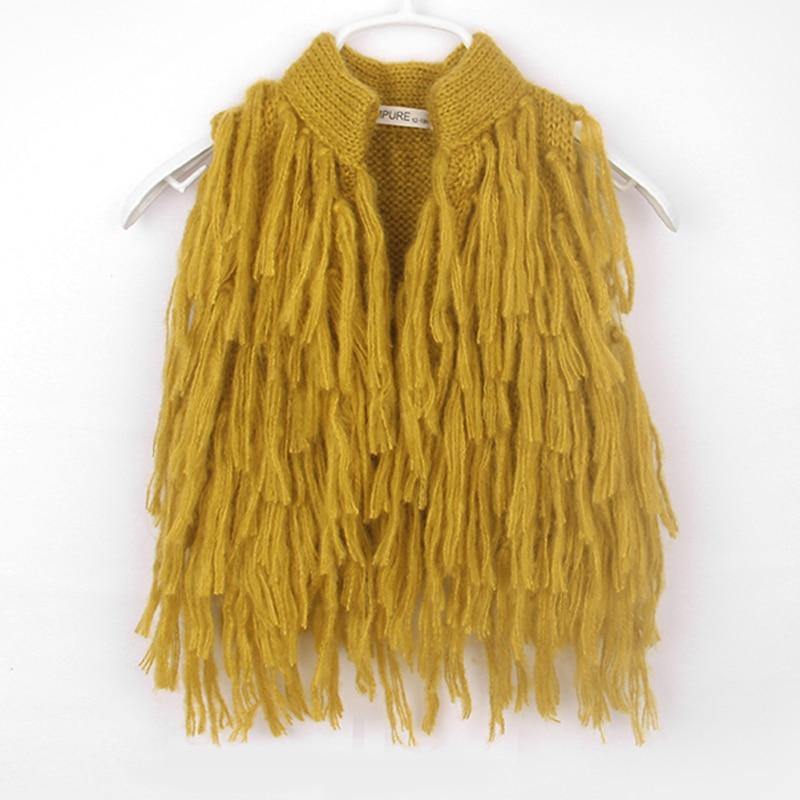 Cute baby girl clothes: a sleeveless knitted shrug with decorative tassels, toddler fashion.