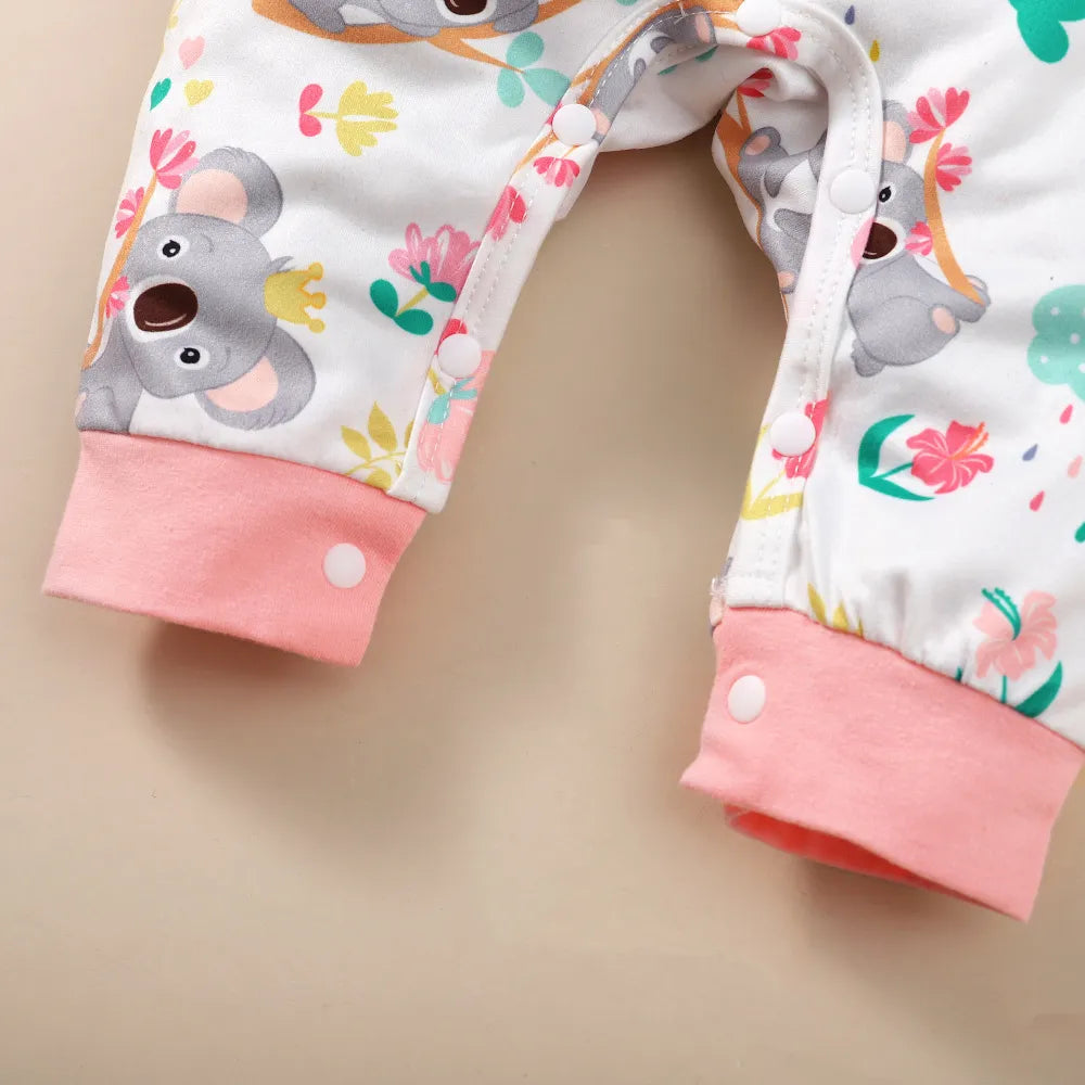 Newborn girl's long-sleeve bodysuit featuring a cheerful cartoon bear design and a soft, pink headband.
