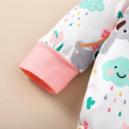 Infant girl's fashion set: long-sleeve white bodysuit with playful cartoon graphics and a bow headband.