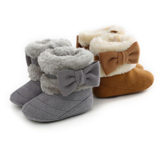 Baby girl's pink suede winter boots with a cute bow, faux fur lined for warmth, anti-slip sole