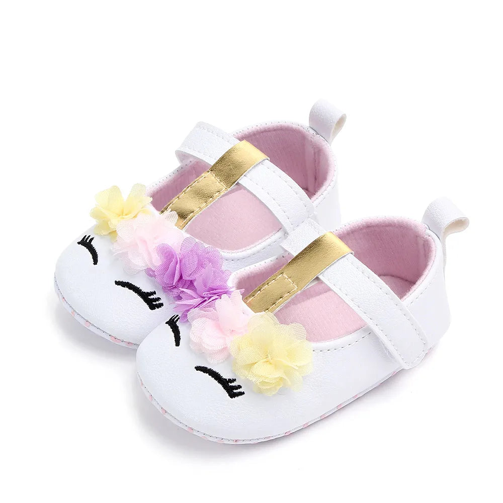 Toddler girl's first steps shoes, gentle pink with charming flower embellishment.