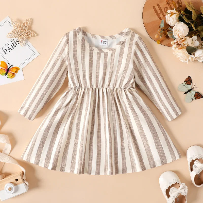 Close-up of the neckline and ribbed texture on a baby girl's striped long sleeve party dress